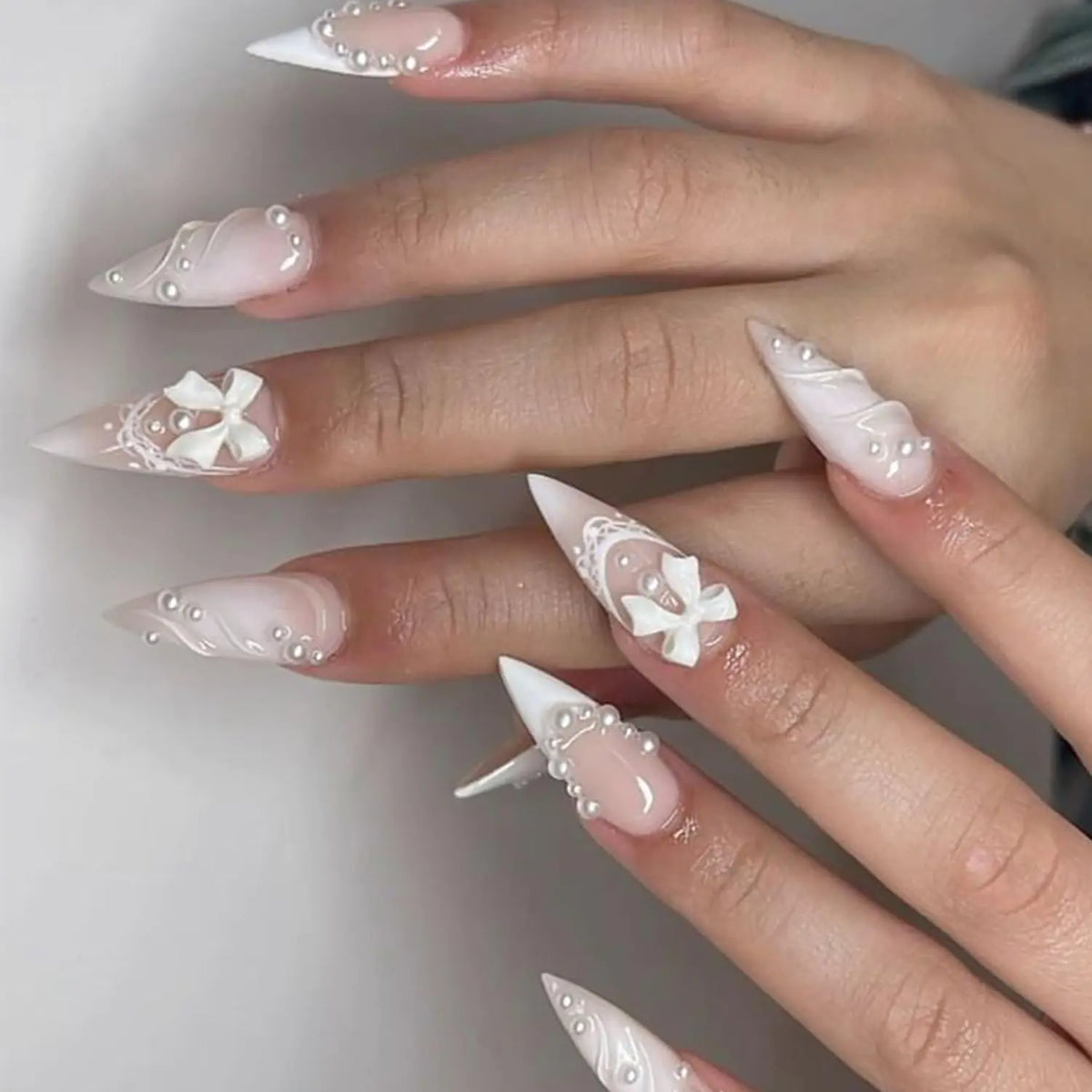 24 Pcs RIICFDD Nails Stiletto Press on Nails Long Almond Fake Nails 3D Curve & Pearl & Bow Nail Charms Artificial Acrylic Nails Full Cover Glossy False Nails for Women and Girls French Nails